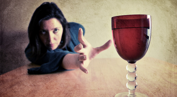 Женщина тянется к бокалу вина
